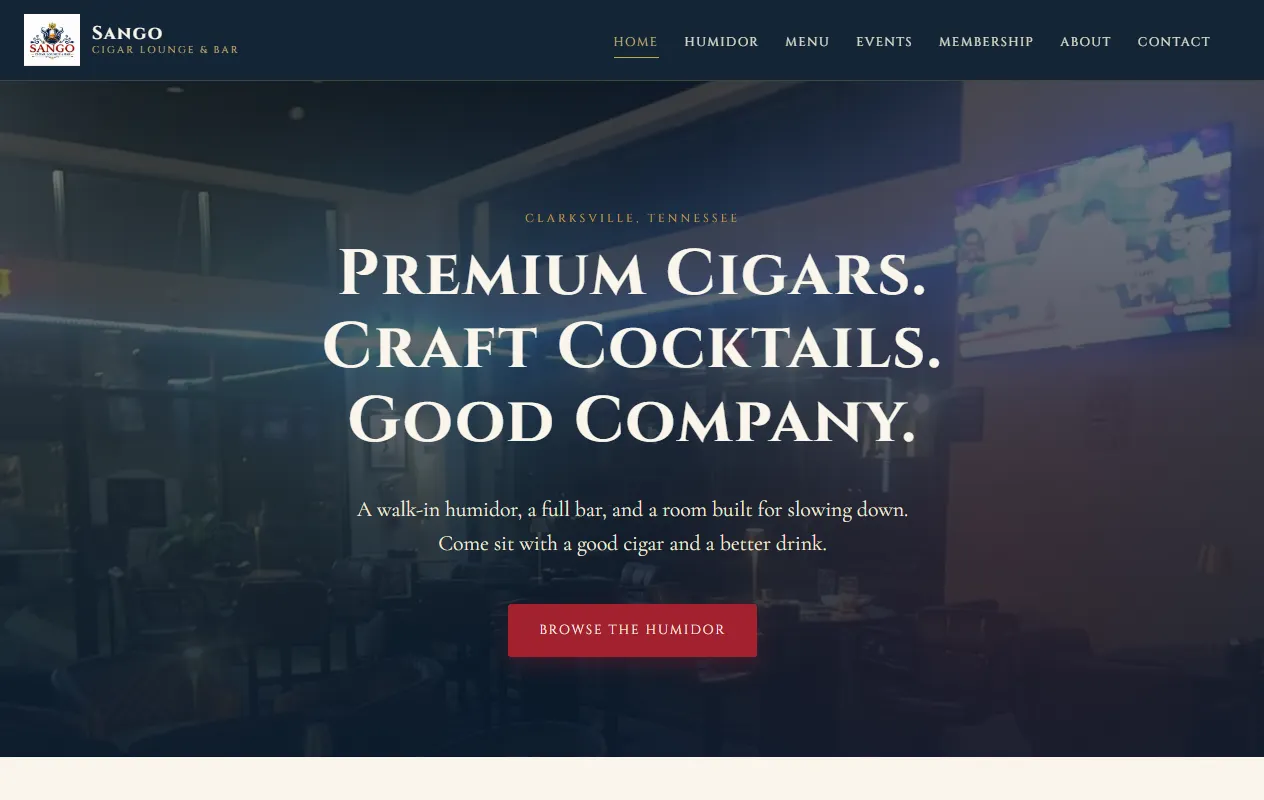 Sango Cigar Lounge homepage: a dim lounge photo behind the headline Premium Cigars, Craft Cocktails, Good Company.